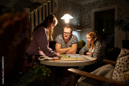 Man playing board game with his daughters photo