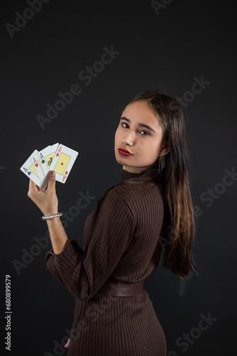 Beautiful poker player holding four aces isolated on black