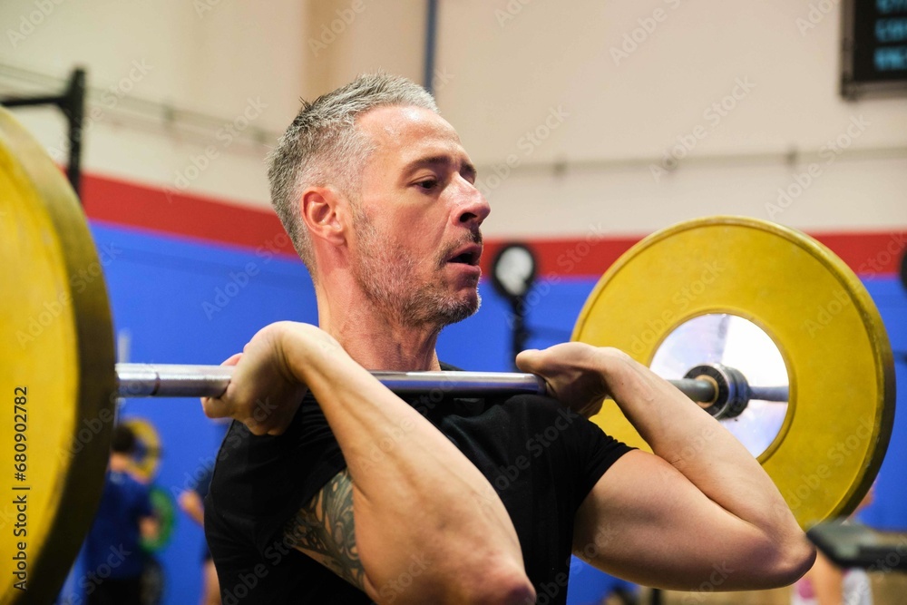 Man practicing front squats in cross training gym. Cross Fit, fitness and sport.