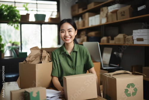 Portrait of young asian woman smiling while unpacking cardboard boxes in office