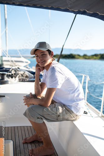 Teen in white tshirt on yacht looking contented