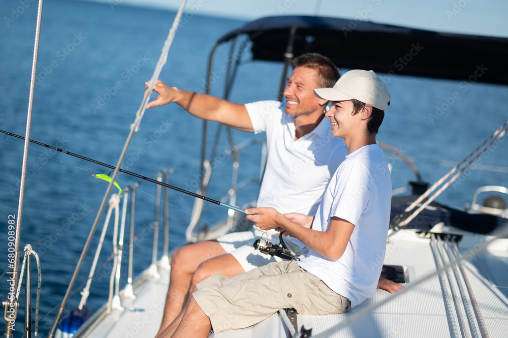Dad and son spending time together on the yacht and fisihing Dad and son spending time together on the yacht and fisihing