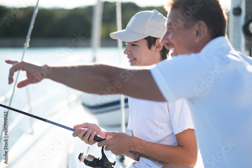 Dad and son spending time together on the yacht and fisihing