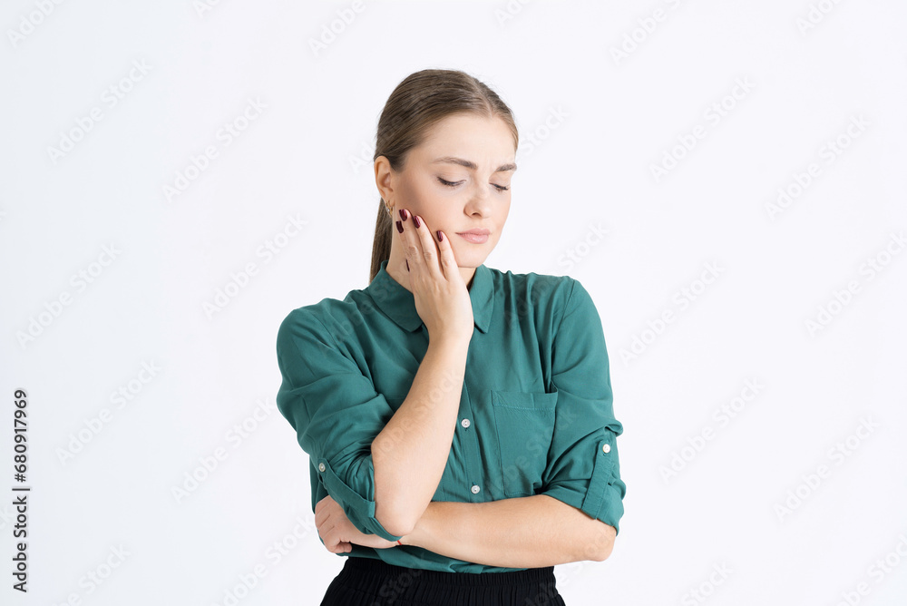 Attractive young woman shows a painful facial expression, touches her cheek because of a toothache isolated on a white studio background. The concept of health care and dental care Attractive young woman shows a painful facial expression, touches her cheek because of a toothache isolated on a white studio background. The concept of health care and dental care