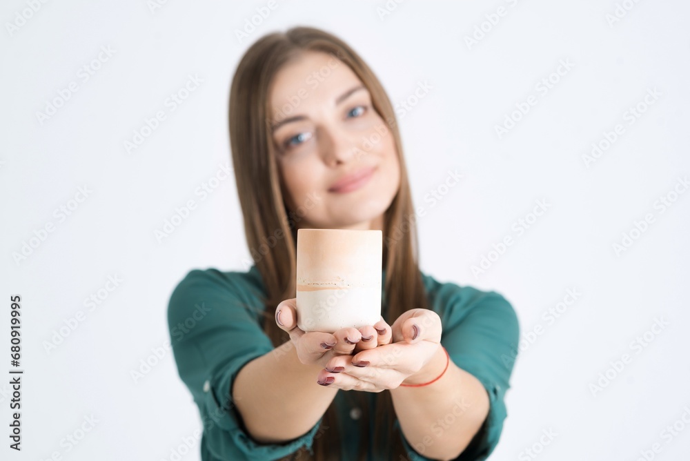 Attractive young woman recommends handmade candles isolated on a white studio background. Advertising handmade candles. Copy space Attractive young woman recommends handmade candles isolated on a white studio background. Advertising handmade candles. Copy space