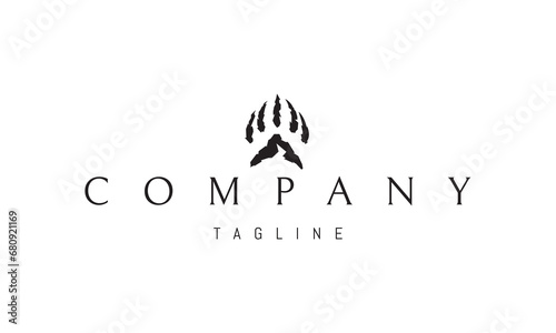 A vector logo with an abstract image of a bear paw with a silhouette of a mountain.