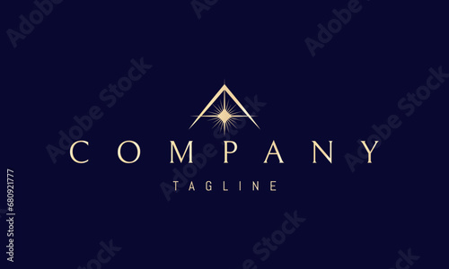 A vector golden logo with an abstract image of a shining star on a mountain background.