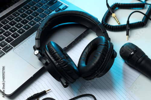 Big headphones, on a table with a laptop.