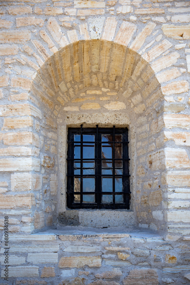 Old window in the stone wall of an ancient castle in Turkey 