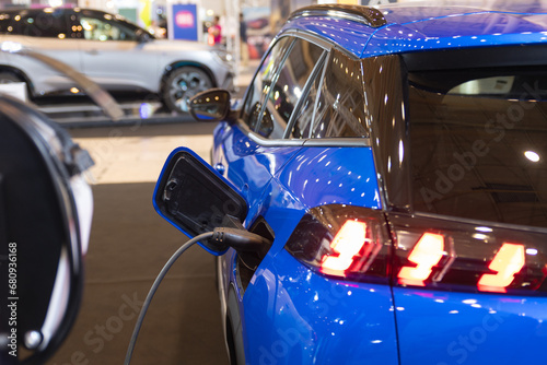 A Blue Car Plugged into an Electric Charger: The Future of Sustainable Transportation