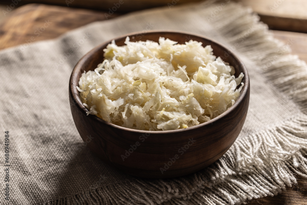 Fermented cabbage in a bowl on wooden cutting board Fermented cabbage in a bowl on wooden cutting board