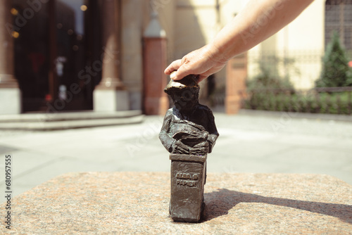 Fototapeta Naklejka Na Ścianę i Meble -  Woman touches small bronze figures of gnomes on the streets of Wroclaw. Europe. High quality photo