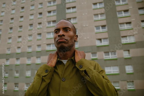 Portrait of young man with autism in street wear posing in front of building