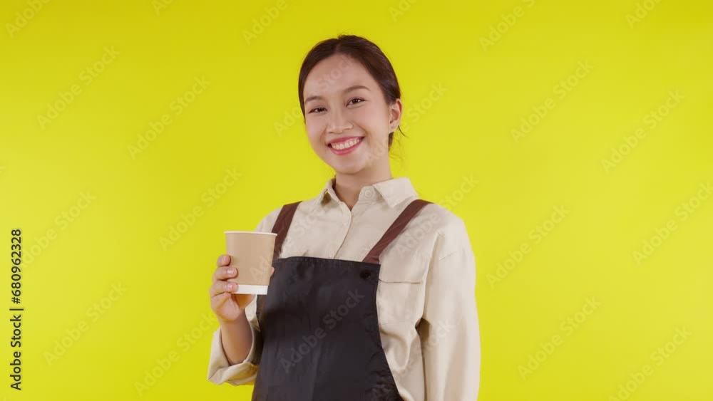 Portrait of young asian barista woman wearing apron smell coffee cup on yellow background, waitress or entrepreneur holding coffee with excited, small business or startup, waiter of cafe. Portrait of young asian barista woman wearing apron smell coffee cup on yellow background, waitress or entrepreneur holding coffee with excited, small business or startup, waiter of cafe.