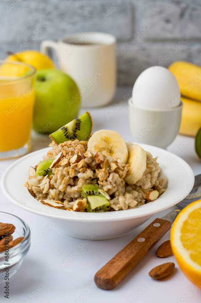 Oatmeal with fruits and nuts, orange juice, egg in a stand, traditional, healthy breakfast. Proper nutrition, diet.. Oatmeal with fruits and nuts, orange juice, egg in a stand, traditional, healthy breakfast. Proper nutrition, diet..
