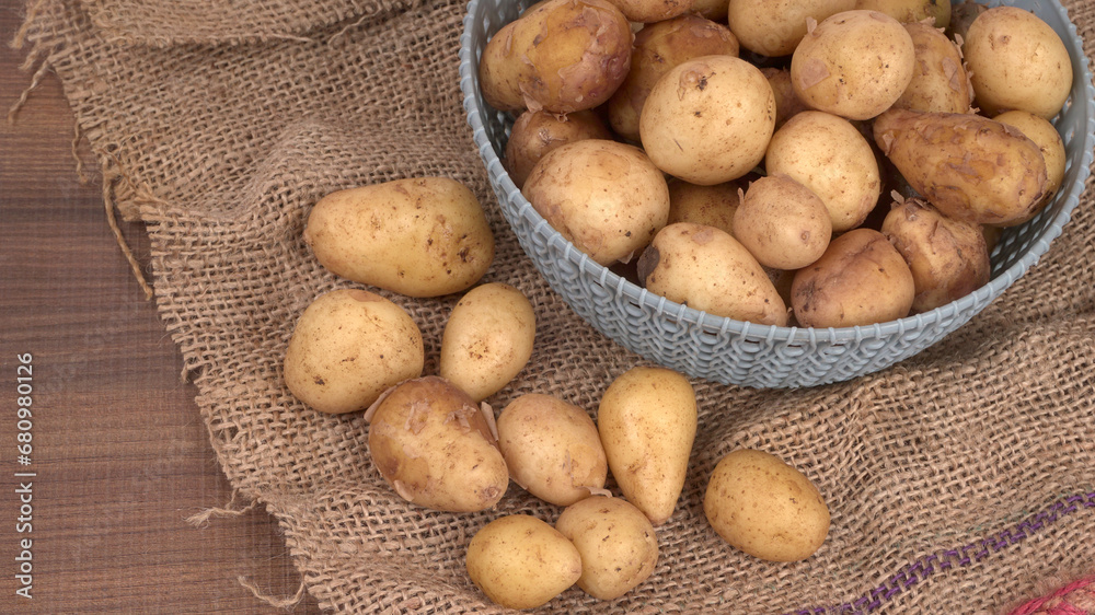Fresh small potatoes for cooking in a wooden bowl. With copy space on white background. Fresh small potatoes for cooking in a wooden bowl. With copy space on white background.