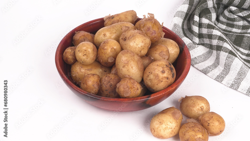 Fresh small potatoes for cooking in a wooden bowl. With copy space on white background. Fresh small potatoes for cooking in a wooden bowl. With copy space on white background.