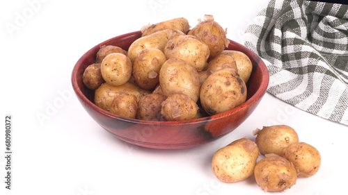 Fresh small potatoes for cooking in a wooden bowl. With copy space on white background.