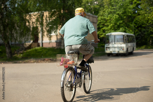 Elderly man on bicycle. Old man rides bicycle. Man in town.