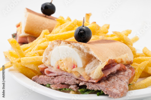 Chivito al pan. El chivito es un sándwich de carne vacuna y otros ingredientes, generalmente aderezado con mayonesa y acompañado de papas fritas, algunas veces con ensalada rusa photo