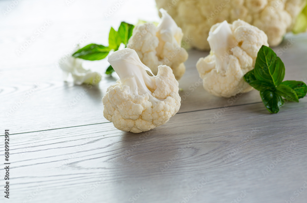 slices of raw small raw cauliflower on wooden table slices of raw small raw cauliflower on wooden table