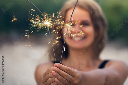 Beautiful woman with sparklers on the beach