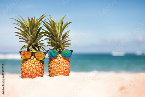 Two pineapples with trendy sunglasses in tropical paradise