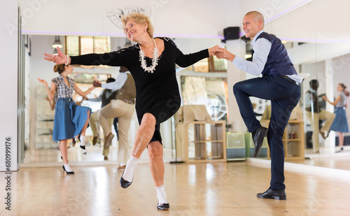 Mature woman dancing swing with young man