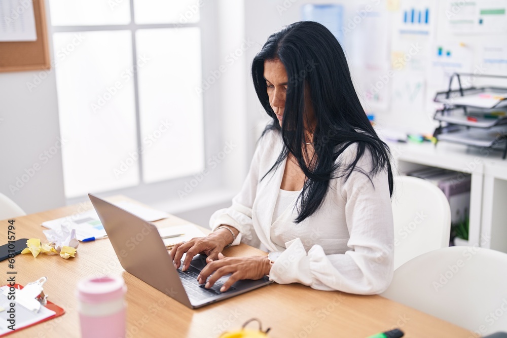 Middle age hispanic woman business worker using laptop working at office Middle age hispanic woman business worker using laptop working at office