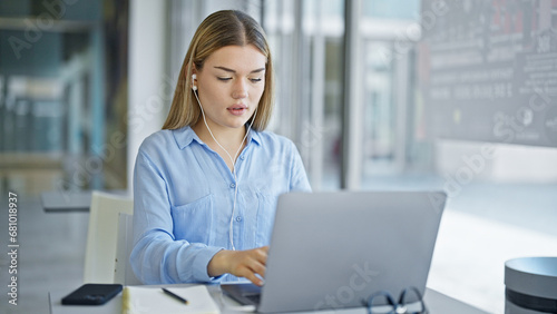 Young blonde woman business worker using laptop and earphones at office © Krakenimages.com