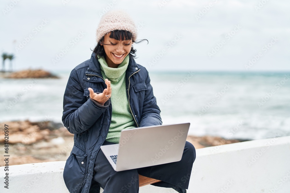 Young beautiful hispanic woman smiling confident having video call at seaside