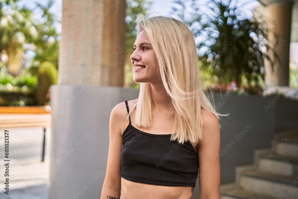 Young blonde woman smiling confident looking to the side at street Young blonde woman smiling confident looking to the side at street