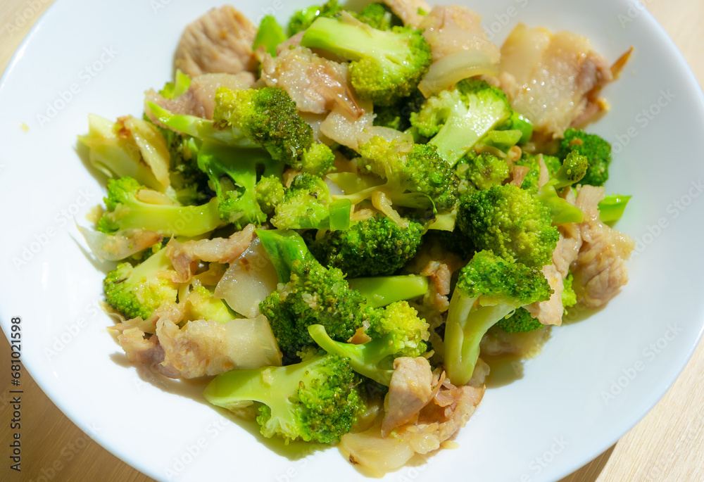 Stir-fried vegetables with pork , Broccoli stir with Thai food style in the white plate. Stir-fried vegetables with pork , Broccoli stir with Thai food style in the white plate.