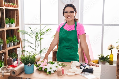 Young hispanic woman florist smiling confident standing at florist
