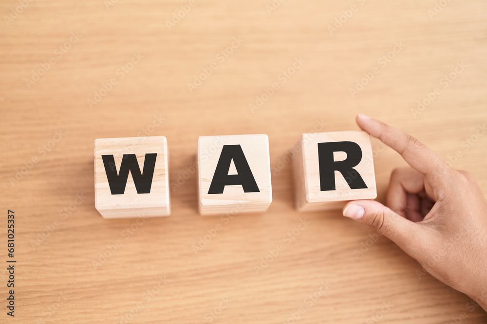 Woman hand holding cubes with war word on the table Woman hand holding cubes with war word on the table