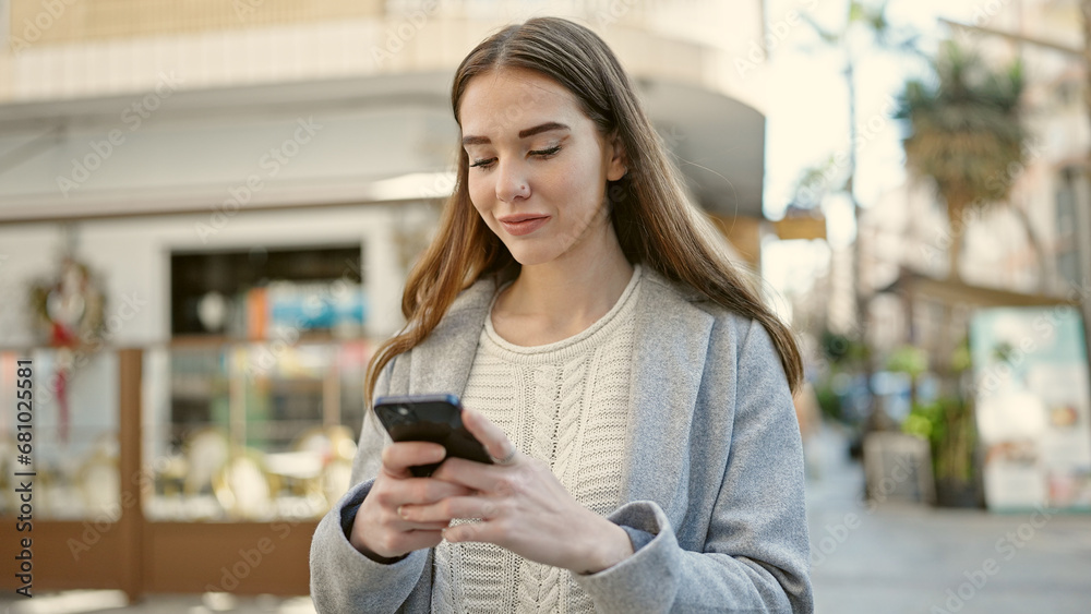 Young hispanic woman using smartphone at coffee shop terrace