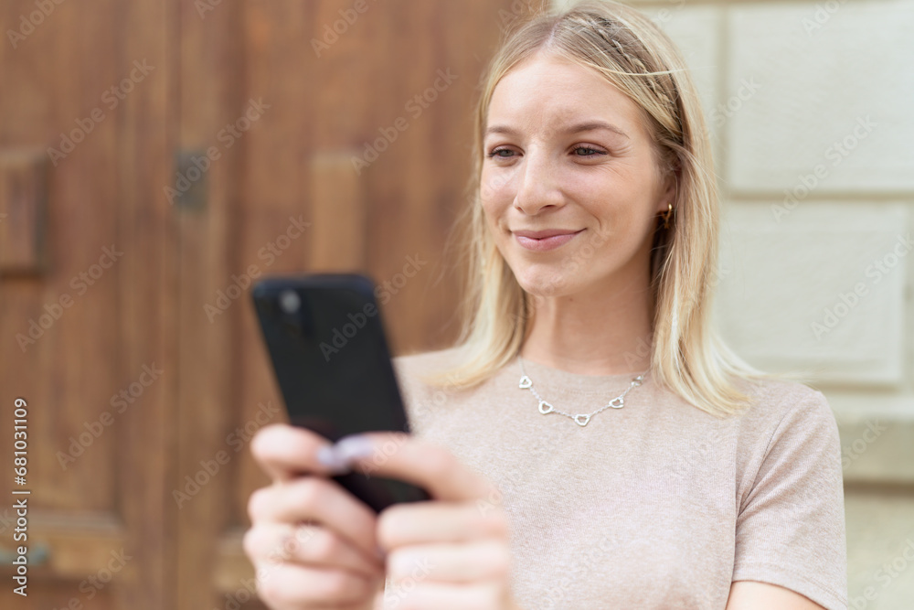 Young blonde woman smiling confident using smartphone at street Young blonde woman smiling confident using smartphone at street