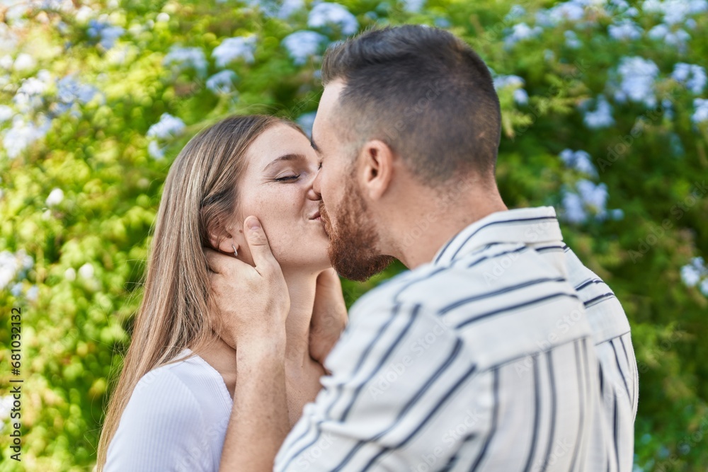 Man and woman couple hugging each other kissing at park