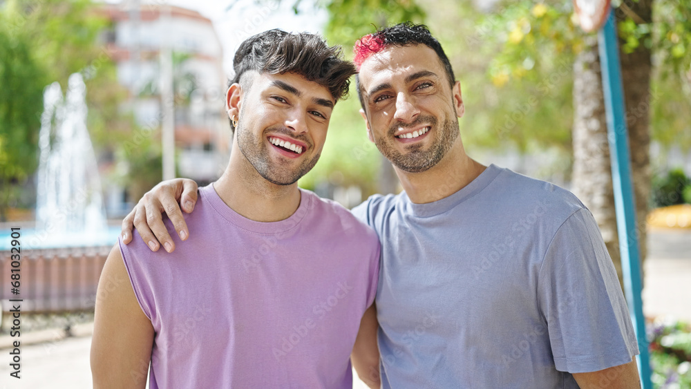 Naklejka premium Two men couple smiling confident hugging each other at park