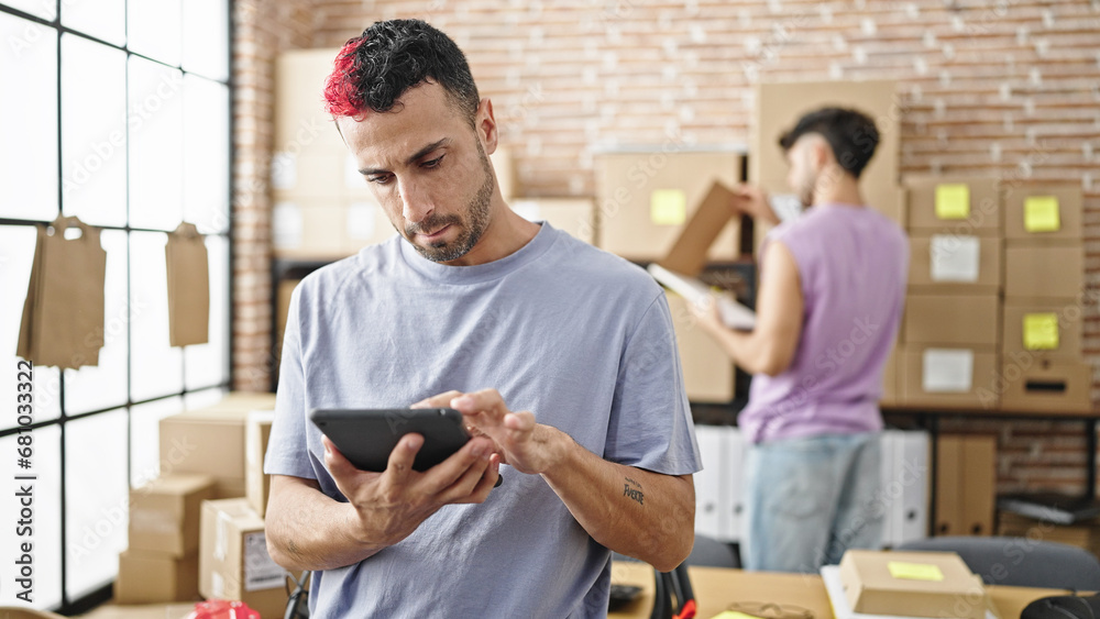 Two men ecommerce business workers using touchpad working at office Two men ecommerce business workers using touchpad working at office