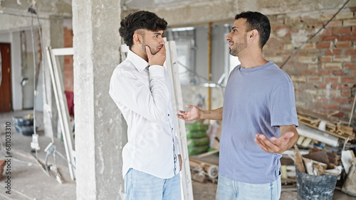 Two men couple speaking at construction site
