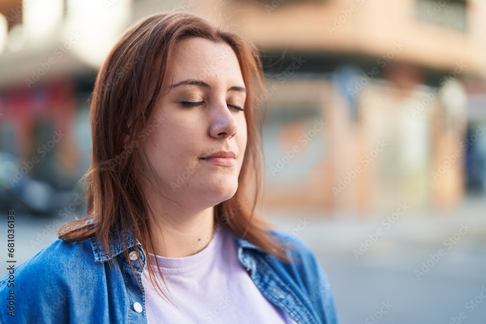 Young beautiful plus size woman breathing with closed eyes at street