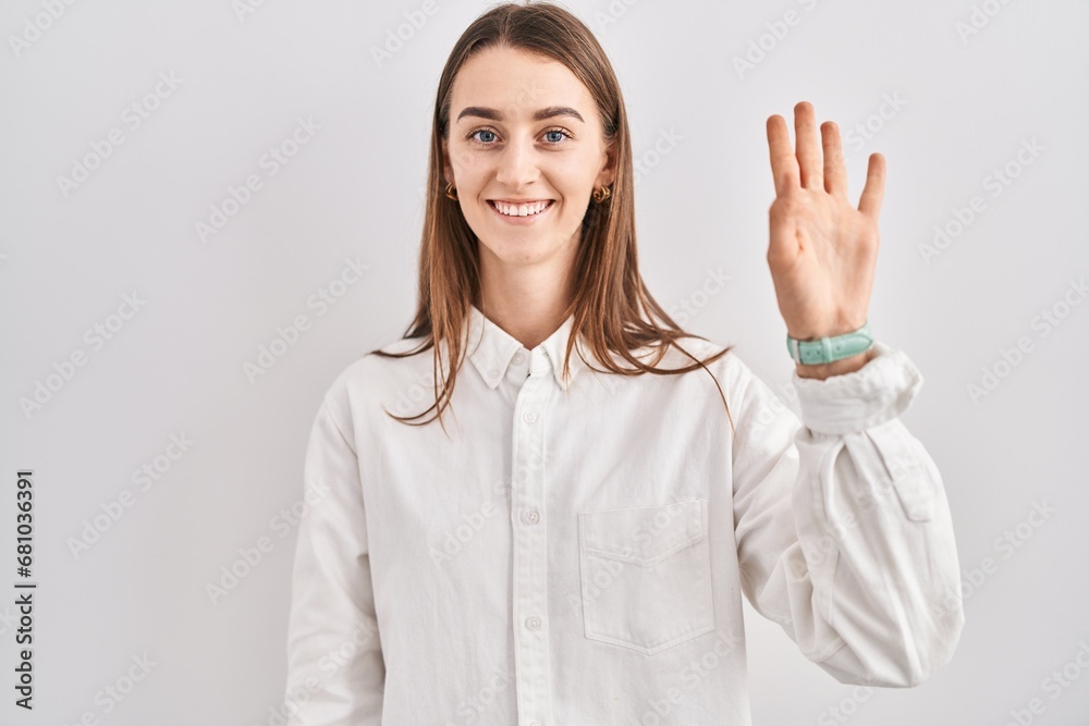 Young caucasian woman standing over isolated background waiving saying hello happy and smiling, friendly welcome gesture Young caucasian woman standing over isolated background waiving saying hello happy and smiling, friendly welcome gesture