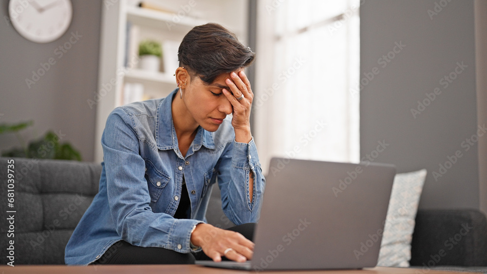 Young beautiful hispanic woman using laptop sitting on sofa stressed at home Young beautiful hispanic woman using laptop sitting on sofa stressed at home