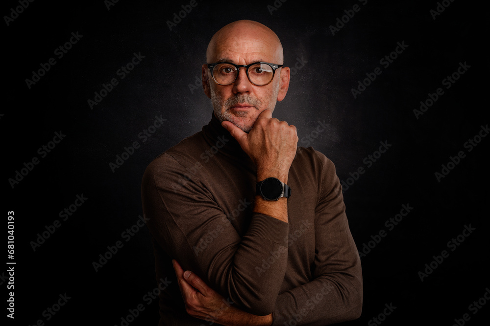 MId aged bald man wearing turtleneck sweater and glasses against isolated background MId aged bald man wearing turtleneck sweater and glasses against isolated background