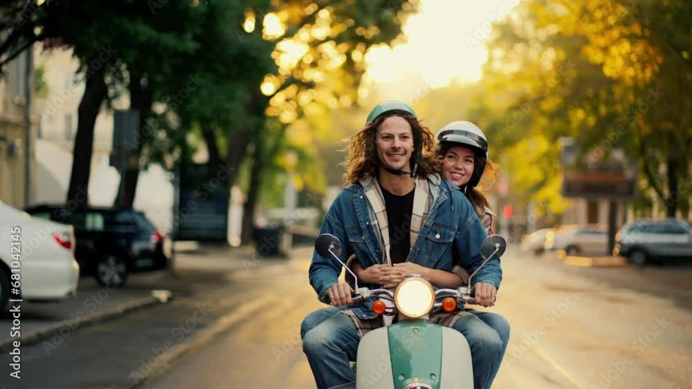 A happy guy in a green moped helmet with long curly hair and a blue
