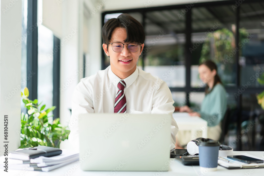 Fototapeta premium Businessman working to typing finance data of business on laptop in modern workplace with colleague