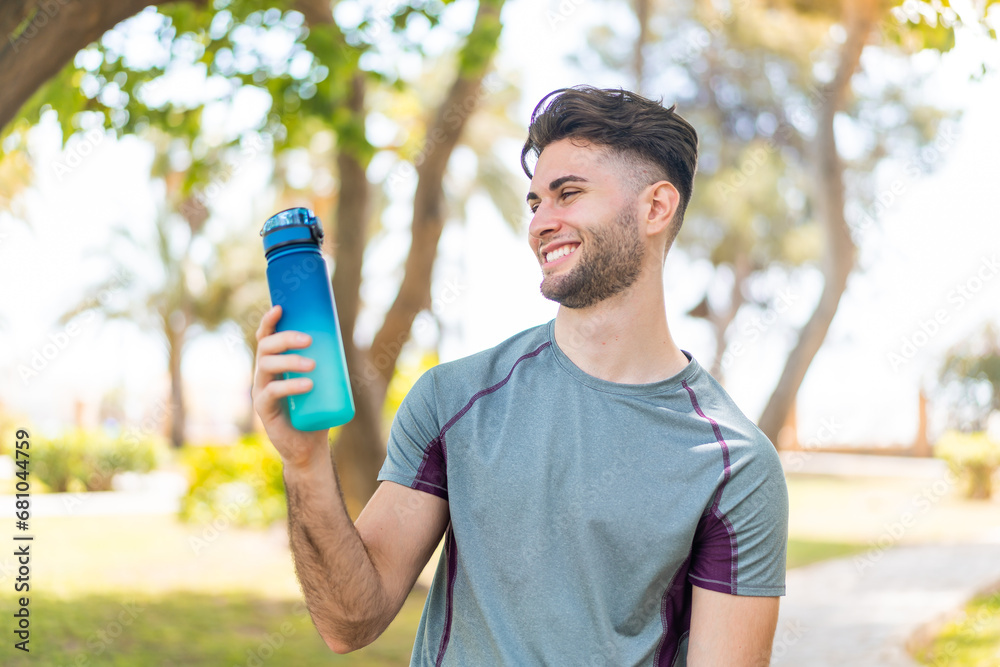 Young handsome sport man with a bottle of water at outdoors with happy expression Young handsome sport man with a bottle of water at outdoors with happy expression