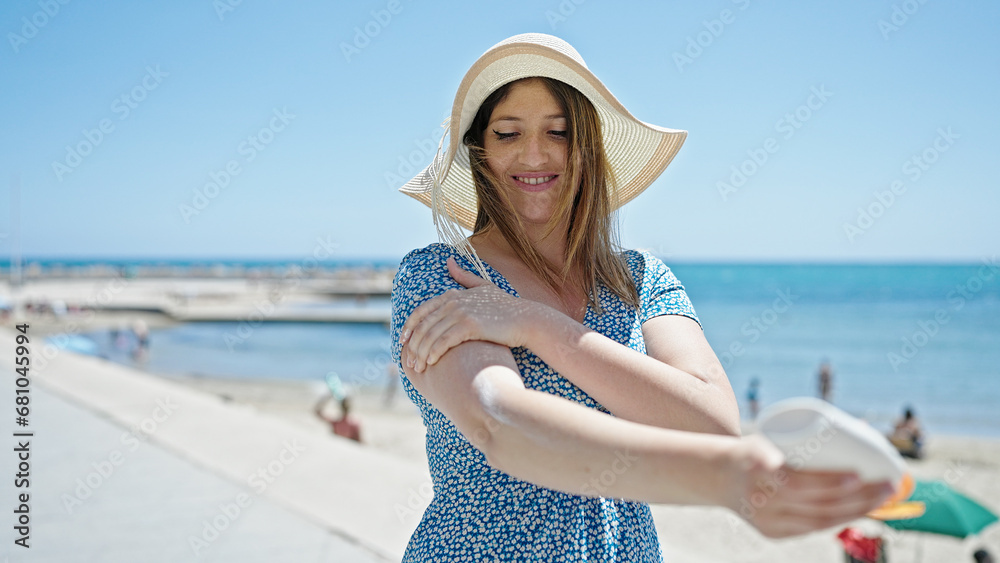 Young blonde woman tourist smiling confident applying sunscreen at seaside Young blonde woman tourist smiling confident applying sunscreen at seaside