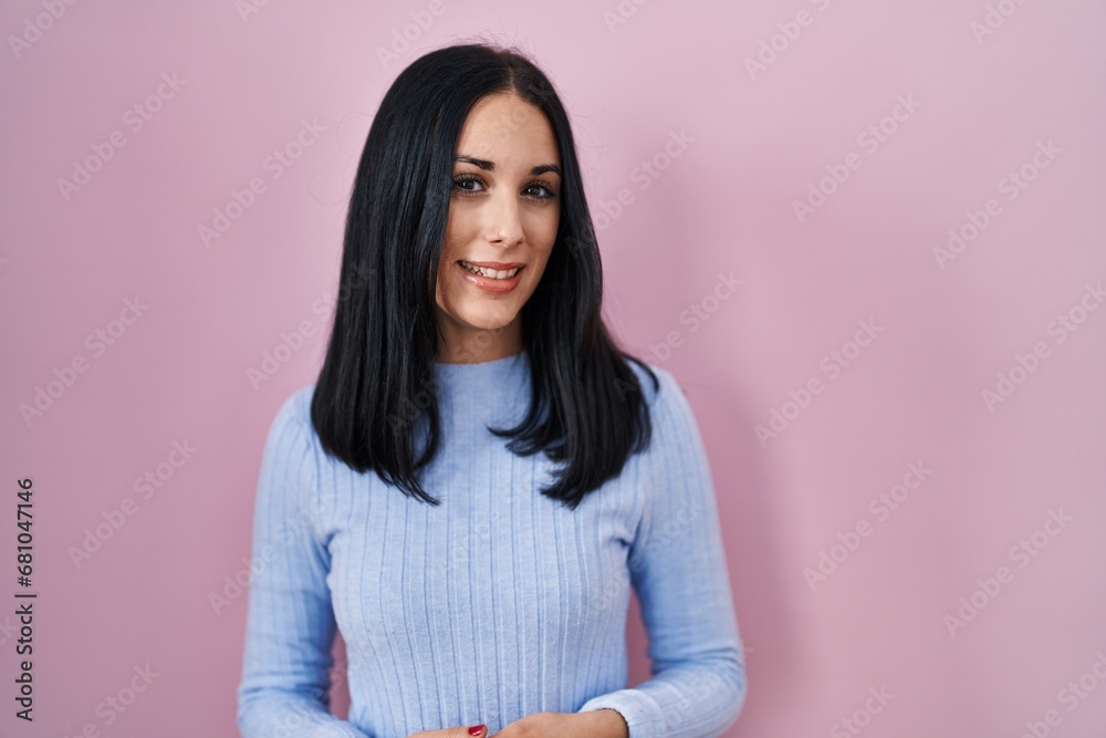 Hispanic woman standing over pink background with hands together and crossed fingers smiling relaxed and cheerful. success and optimistic Hispanic woman standing over pink background with hands together and crossed fingers smiling relaxed and cheerful. success and optimistic